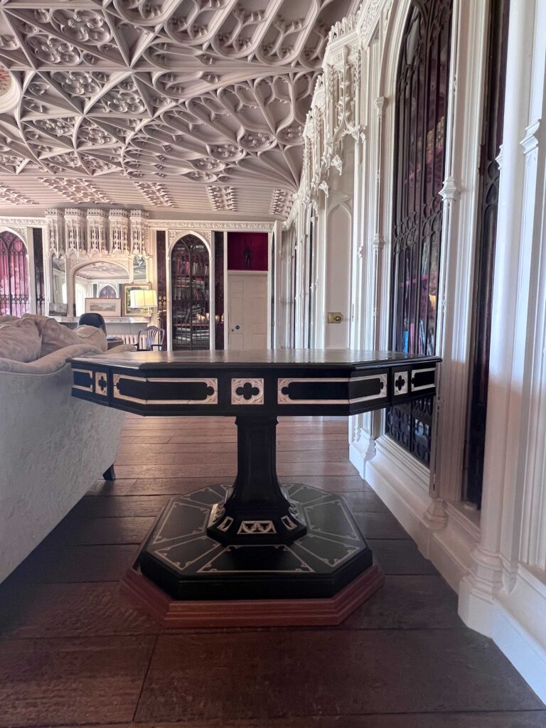 A dark octagonal shaped table with ivory inlay in a Gothic Revival style.